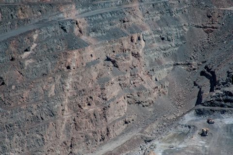 Current working area with earlier mining tunnels in cliff above,