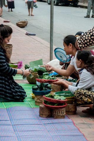 Purchasing breakfast alms to give, Luang Prabang, Laos